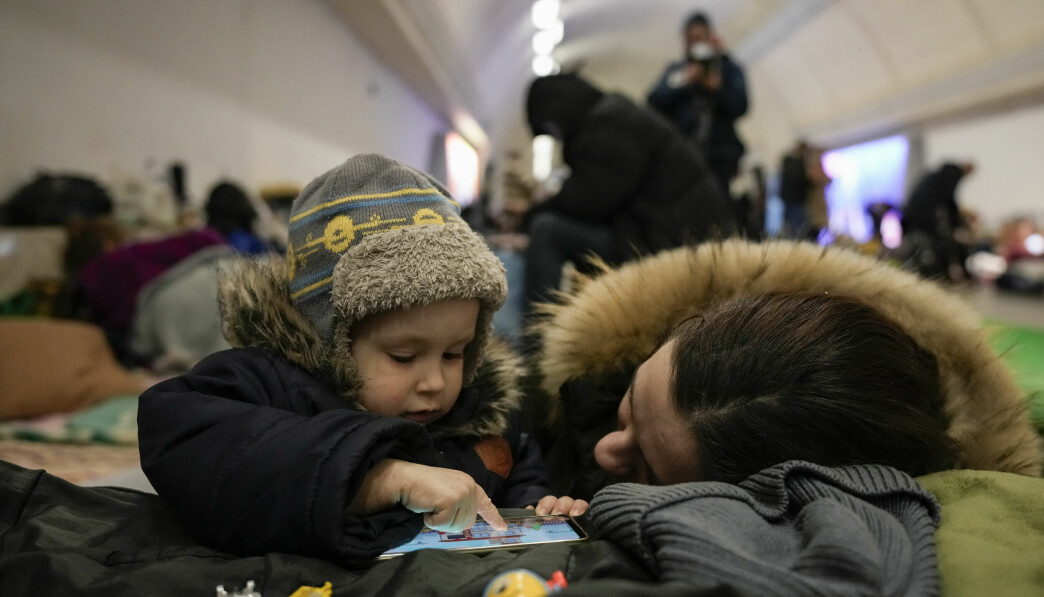 Ett barn och barnets mamma sitter i en tunnelbanestation i Kiev, Ukraina. TT / AP