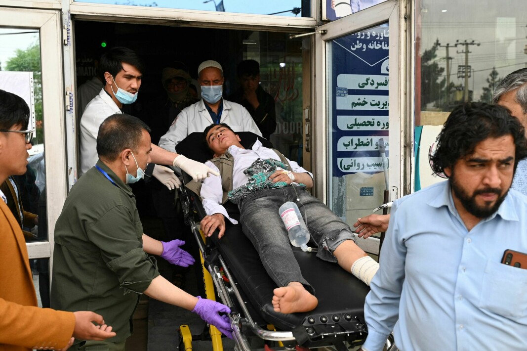 Sjukvårdare tar hand om en skadad ungdom efter flera explosioner vid en pojkskola i Kabul.