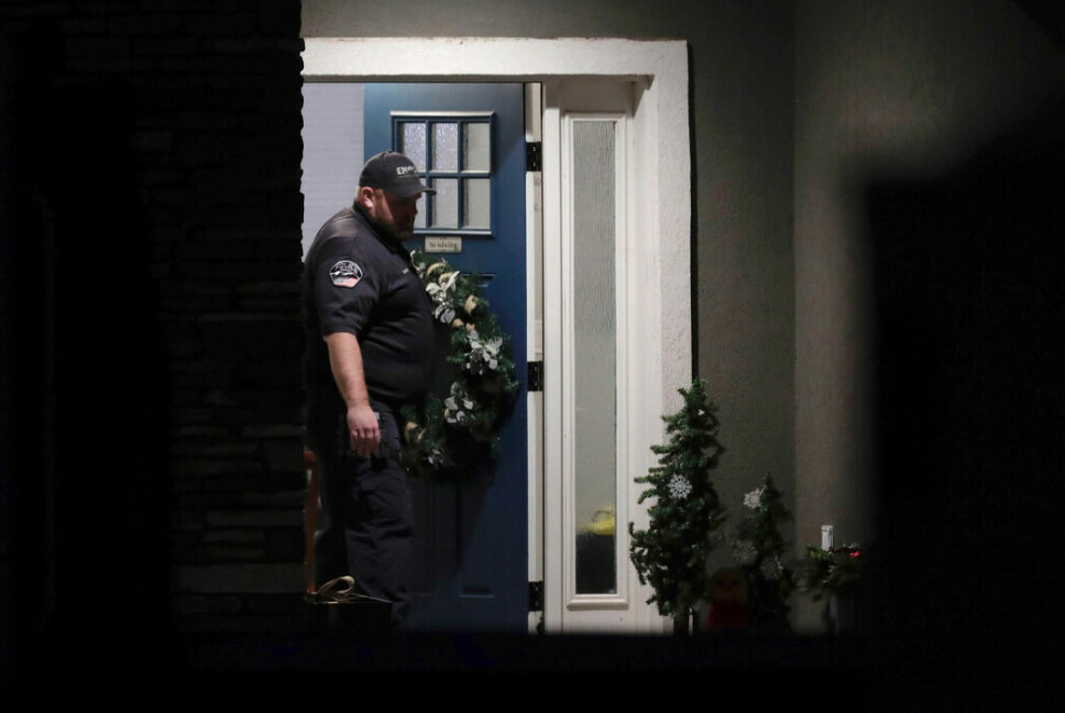 En polisman står vid dörren där familjemedlemmarna hittades döda.