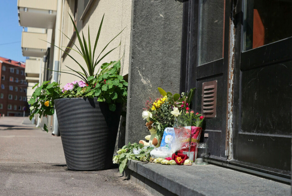 Blommor utanför porten där en pojke föll ner i ett hisschakt och senare avled av sina skador.